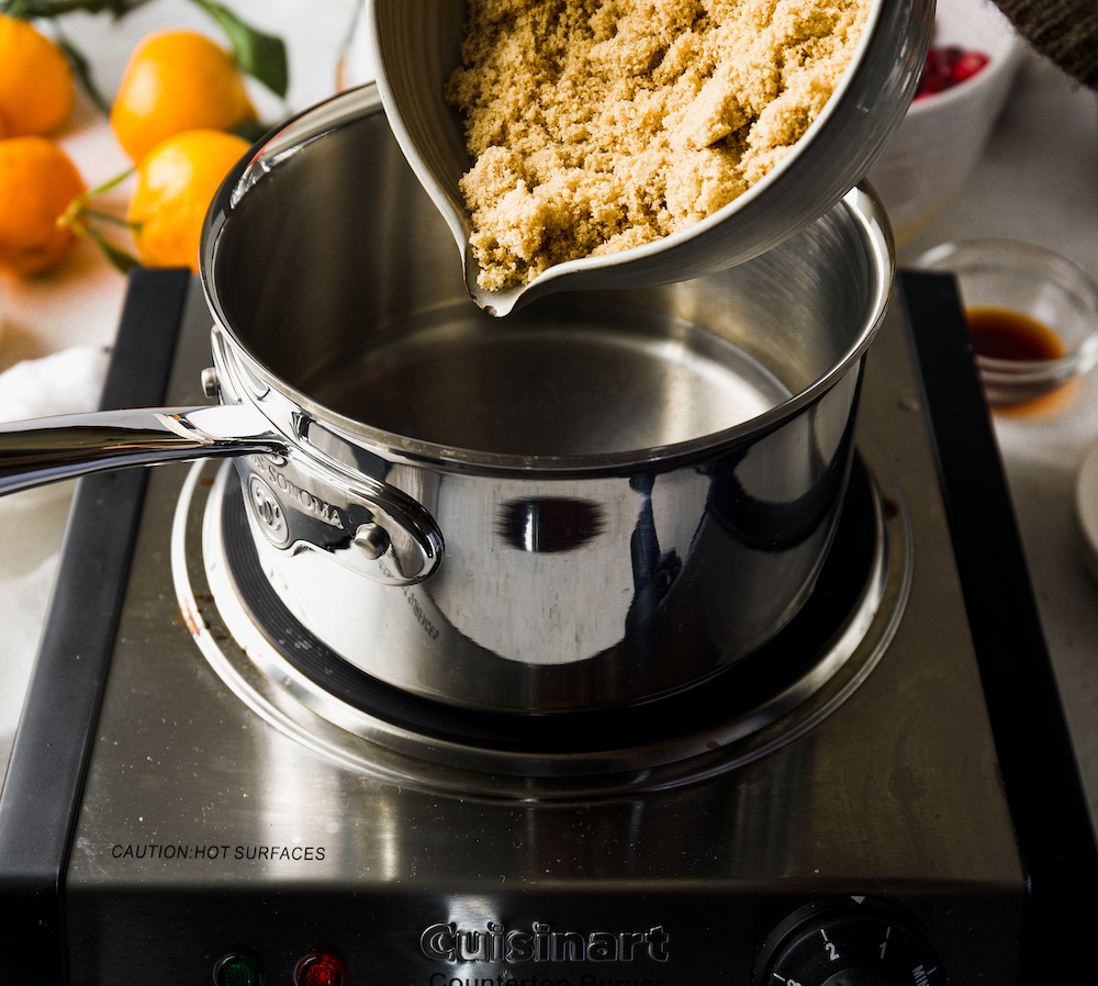 Pouring brown sugar into a saucepan.