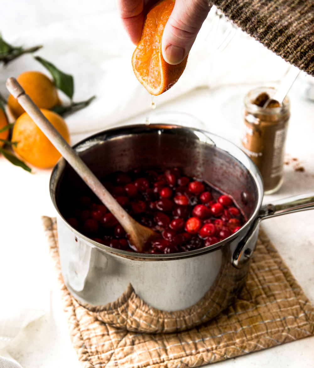 Squeezing an orange into cranberry  sauce.