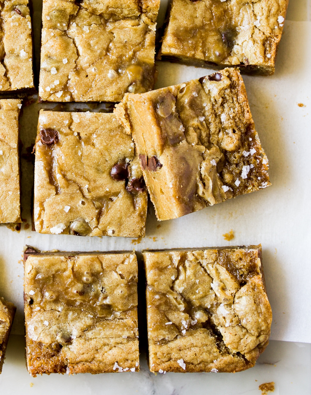 Blondies with sea salt flakes and one with a bite out of it.