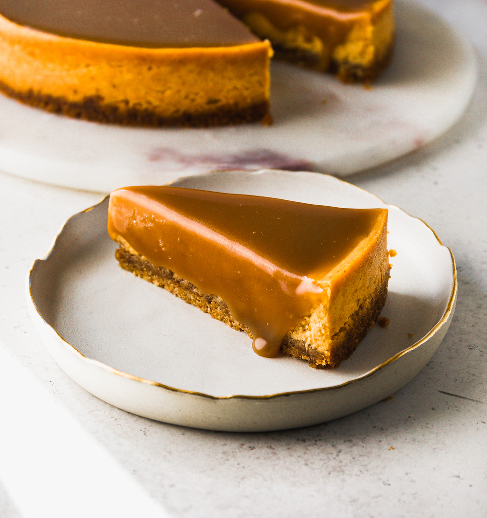 A slice of pumpkin cheesecake with caramel sauce.
