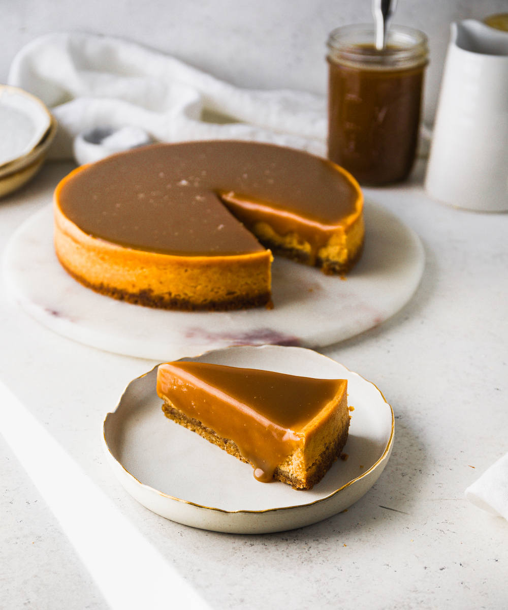 A pumpkin cheesecake with a slice out of it.