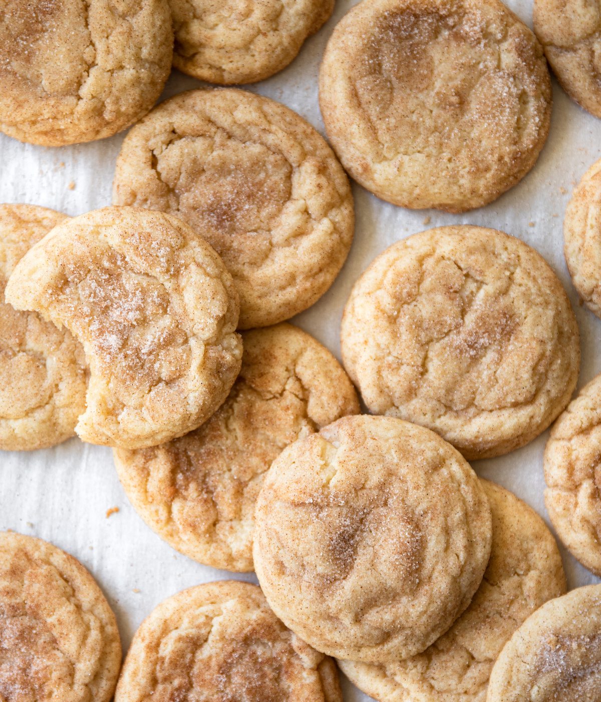 A bunch of super soft snickerdoodles on a white surface.