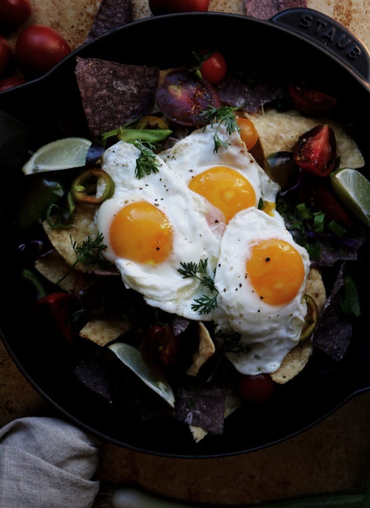 Breakfast Nachos | Recipe via DisplacedHousewife | A layer of tortilla chips, sharp white cheddar (but you can use yellow), thinly sliced fresno chilis, heirloom tomatoes, fresh-cut cilantro + an olive oil fried egg (OBSESSED)...yup, this is how we're doing breakfast. Mid-week. It's that fast and easy...not so much a recipe, but a guide to something really grub. That would be equally delicious for dinner or at 2am after the bars close. You decide! @displacedhousewife xo