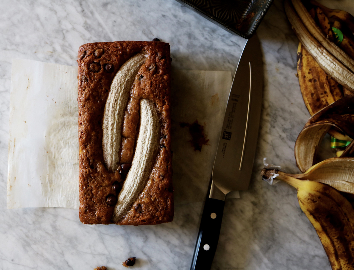 One loaf of banana bread with a banana baked into the top.