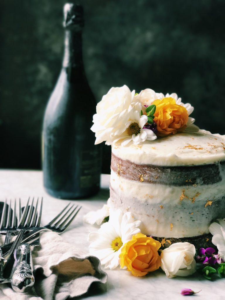 Gilded Dark Chocolate Cake With Champagne Buttermilk | Recipe via DisplacedHousewife | This all sounds fancy, and it's for a fancy occasion, but we break it down into easy steps...including some make ahead stuff. A rich, buttermilk-driven chocolate cake is coated in a balanced champagne buttercream. Gold leaf is placed about and flowers brighten up the whole mood. Yep. It's Awards Season. Time to bust our your spanx and sequins. And this cake. xo