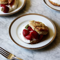 A split scone with whipped cream and fresh strawberries