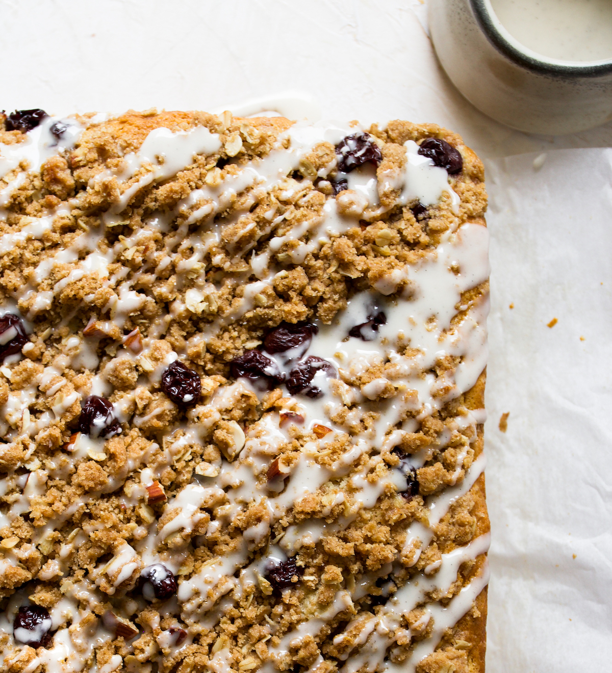 Cherry streusel coffee cake on white parchment paper.