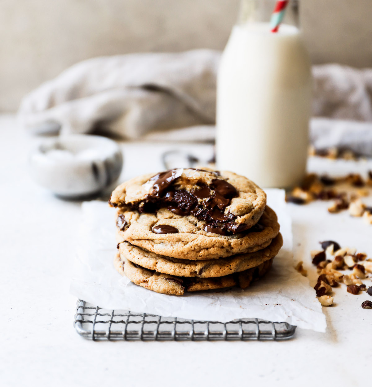 A stack of cookies with a glass of milk in the background.