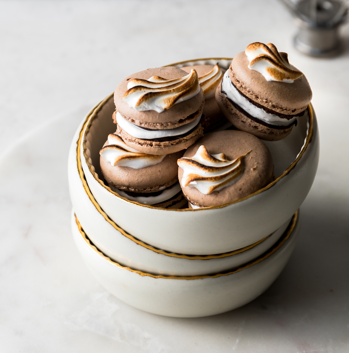 A bowl of chocolate French macarons with marshmallow filling