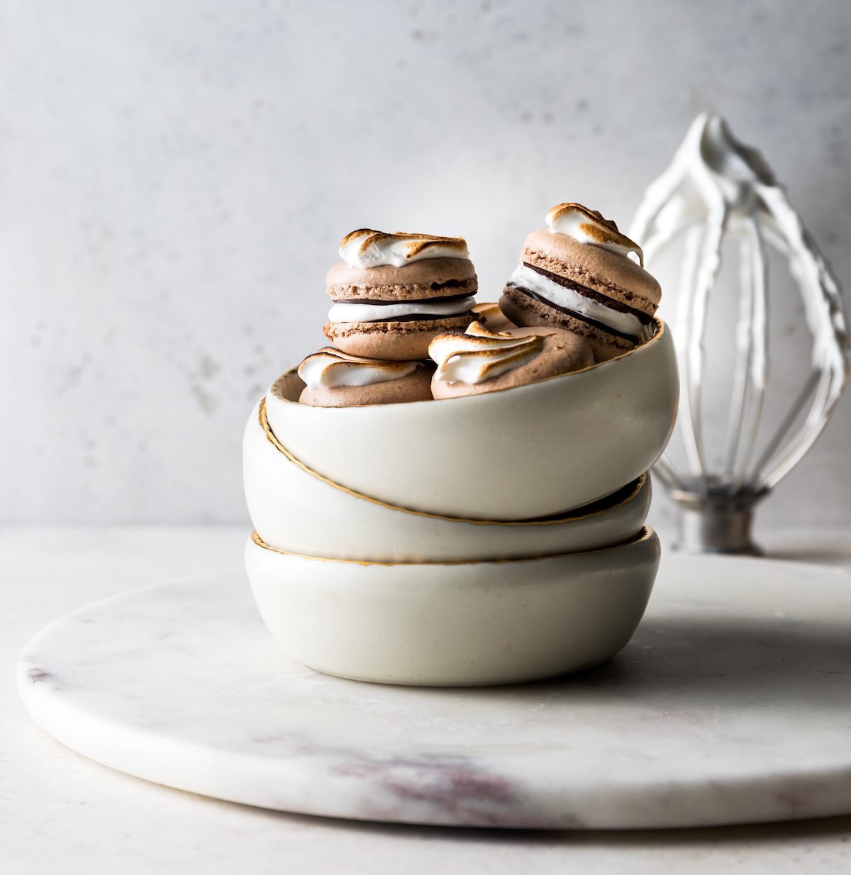 A bowl of chocolate French macarons with marshmallow filling and mexican hot chocolate glaze
