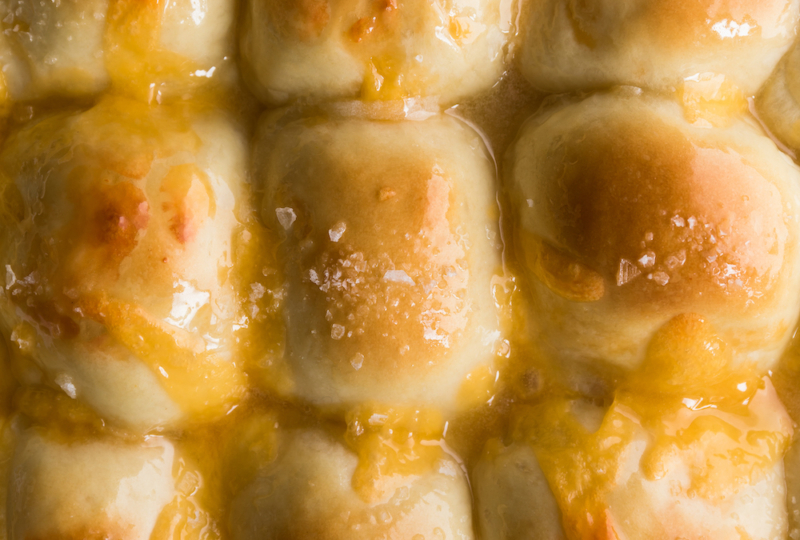 Close up photo of cheesy dinner rolls.