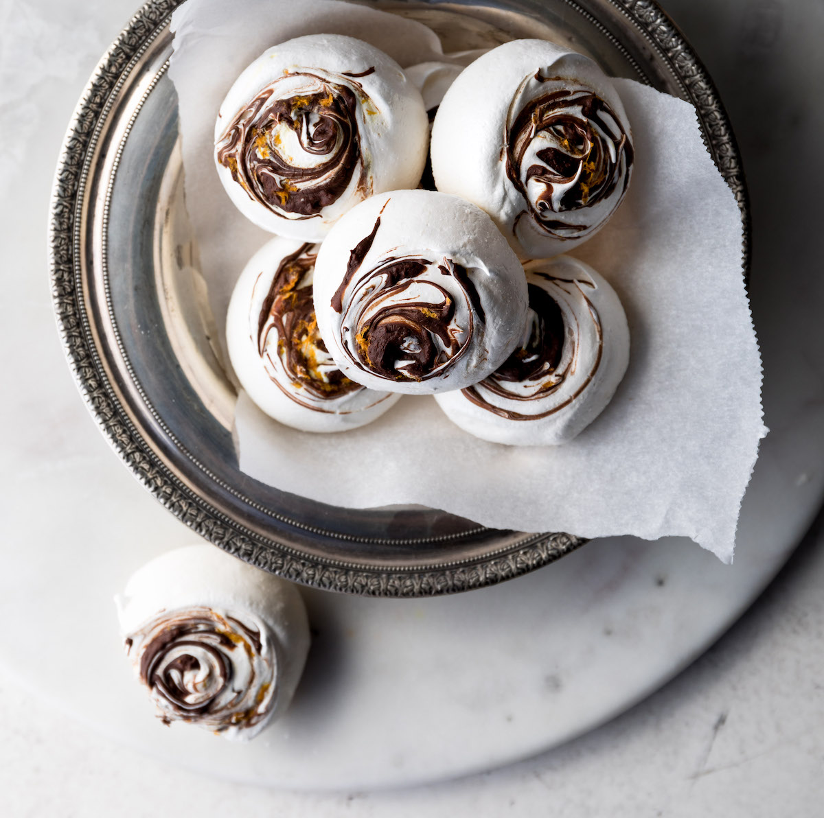 Chocolate ORange Meringue Cookies in a bowl lined with parchment paper.