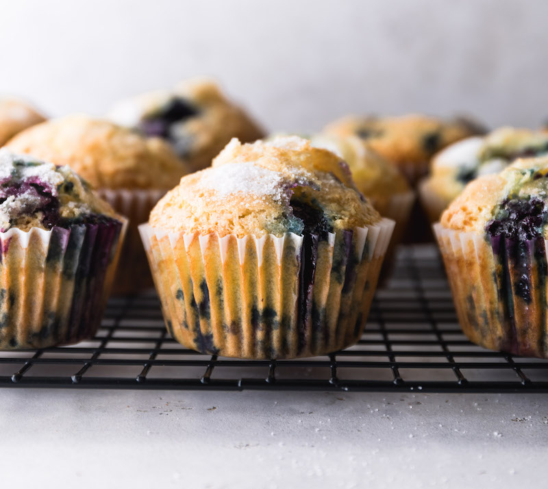 A close up side profile of blueberry muffins.