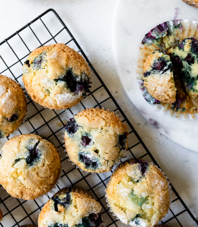 Fresh-baked blueberry muffins on a cooling rack.