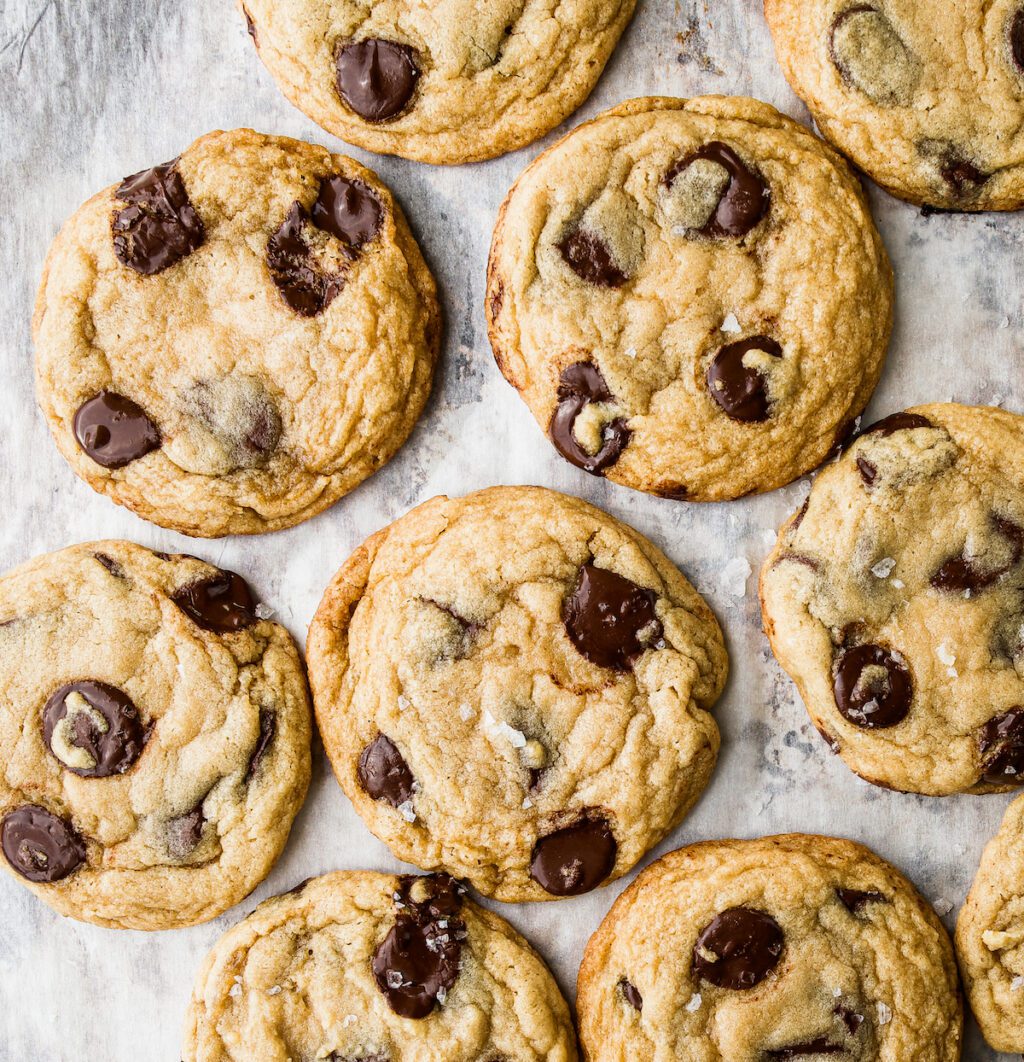 A bunch of mega vanilla chocolate chip cookies on a baking sheet covered in parchment paper.