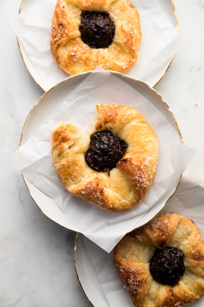 Three flaky danishes with a bite out of it