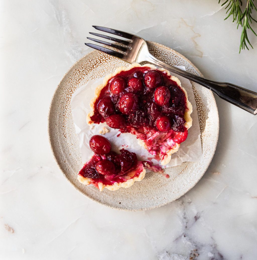 A single cranberry tart with a bite out