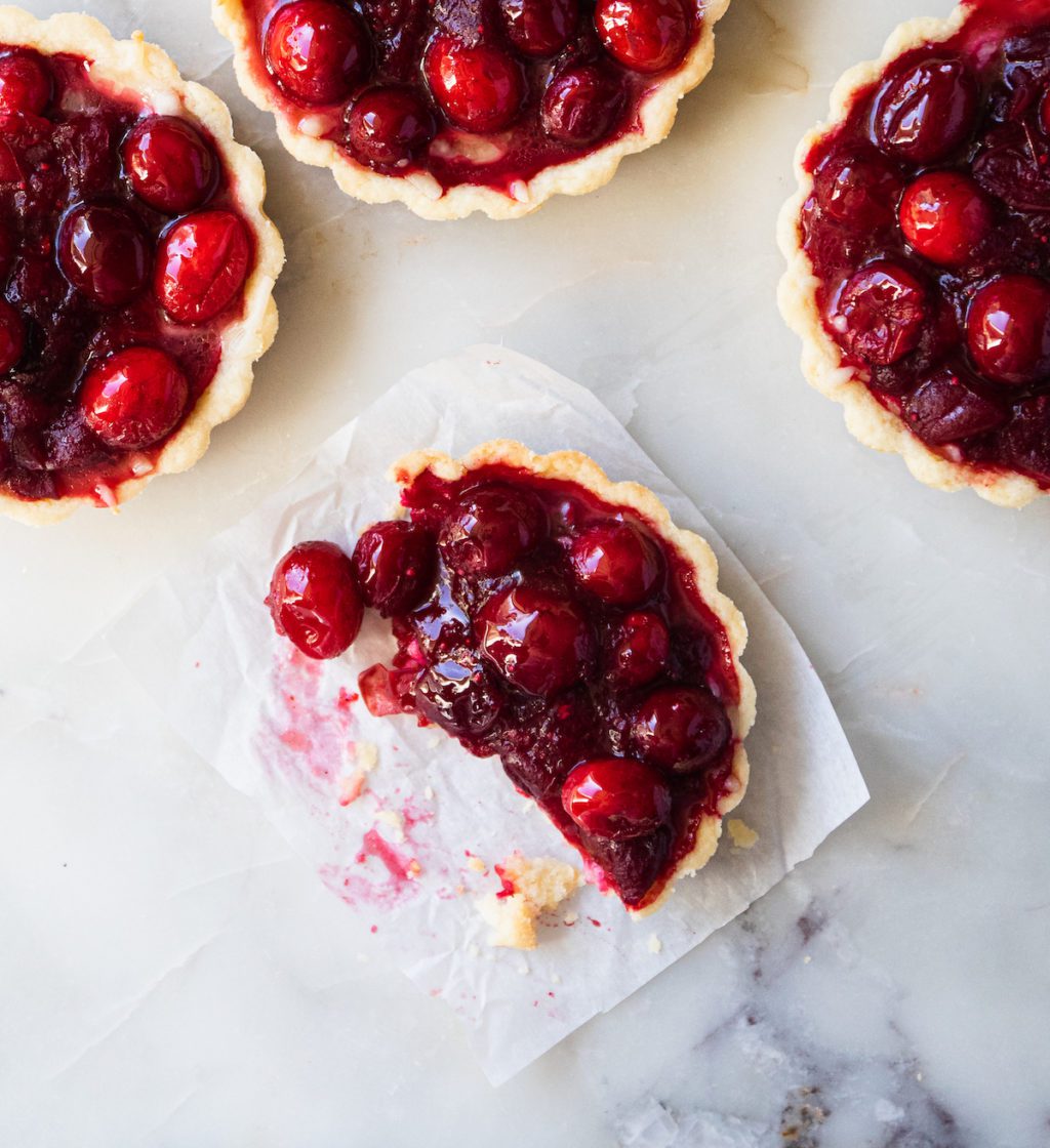 a close up of a cranberry tart with a bite missing