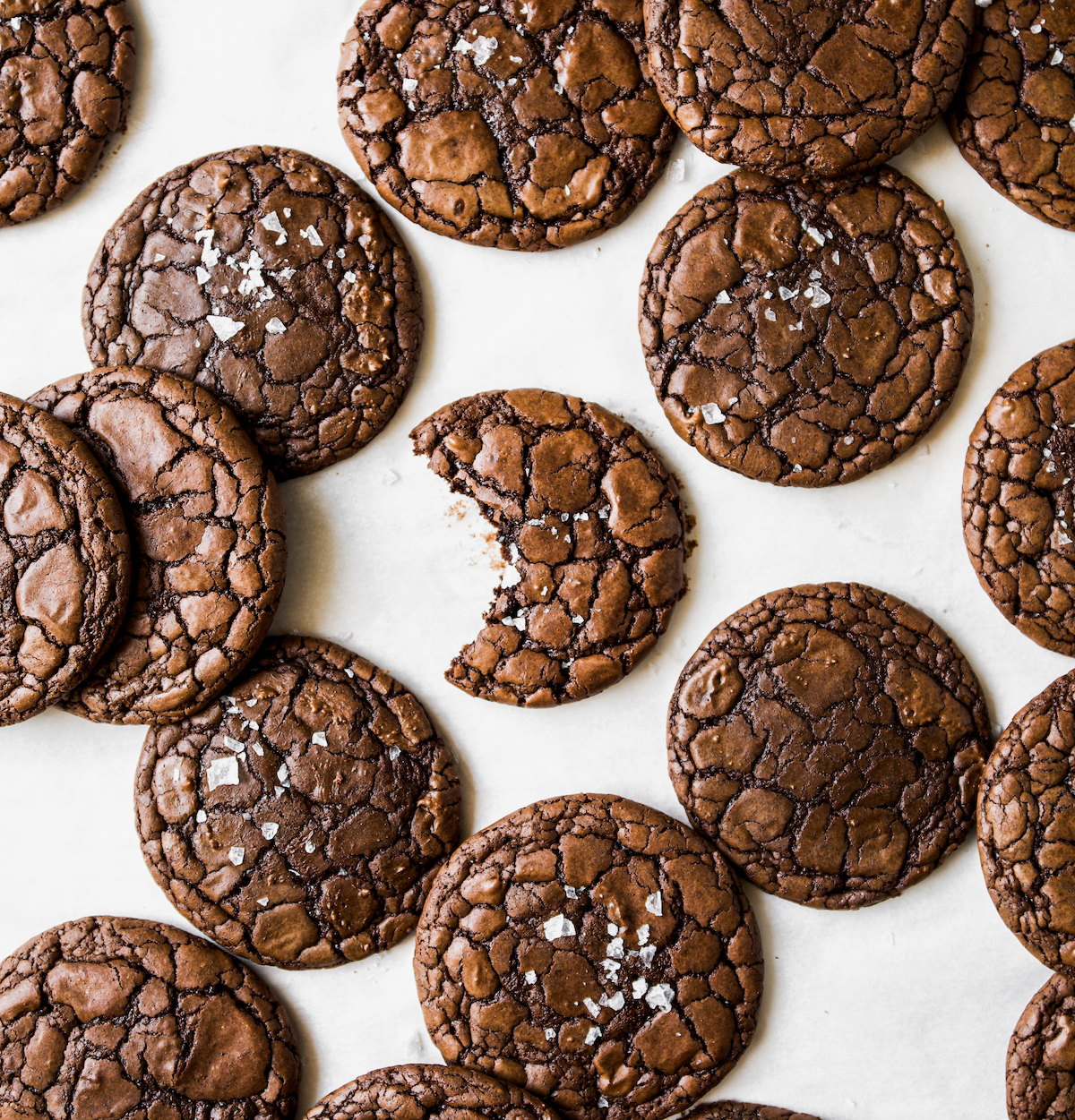 lots of brownie cookies, one with a bite out of  it