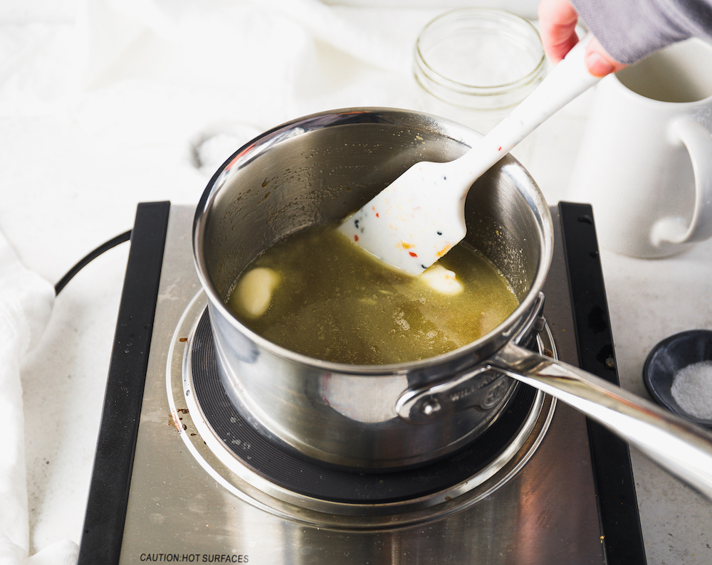 Stirring butter and sugar in a saucepan.