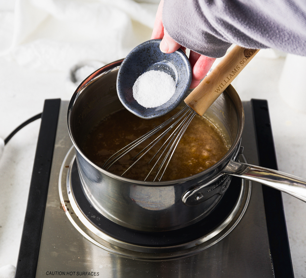 Pouring salt into a saucepan.