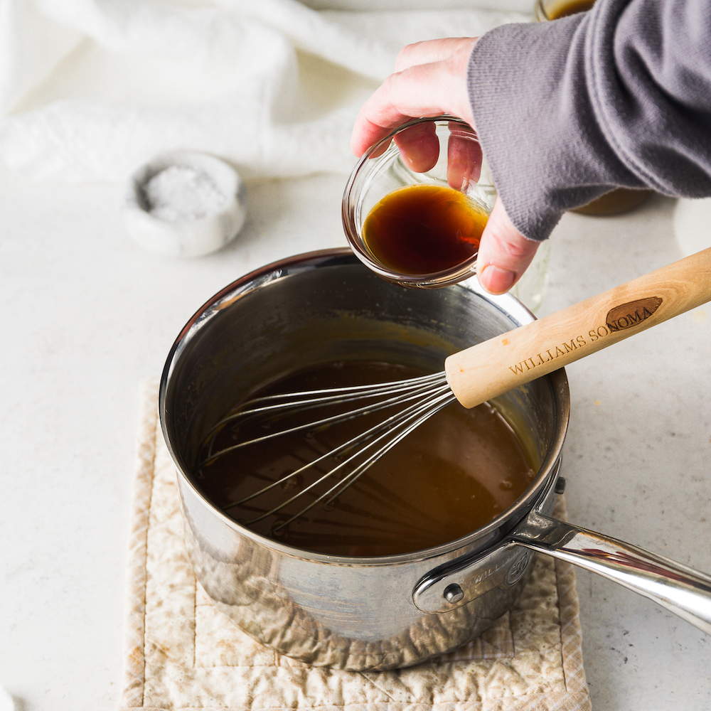 Pouring vanilla into a saucepan.