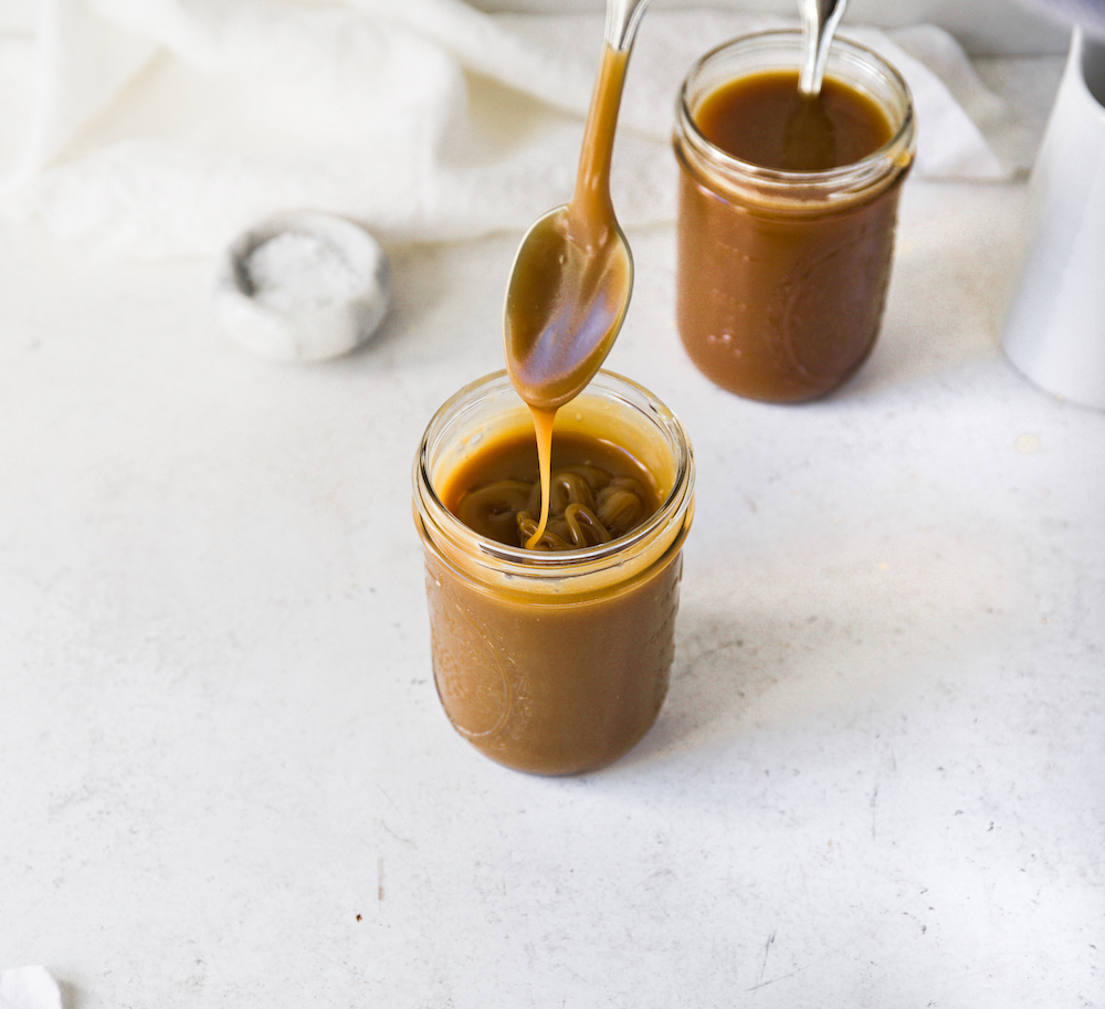 A  jar of caramel sauce against a white background.
