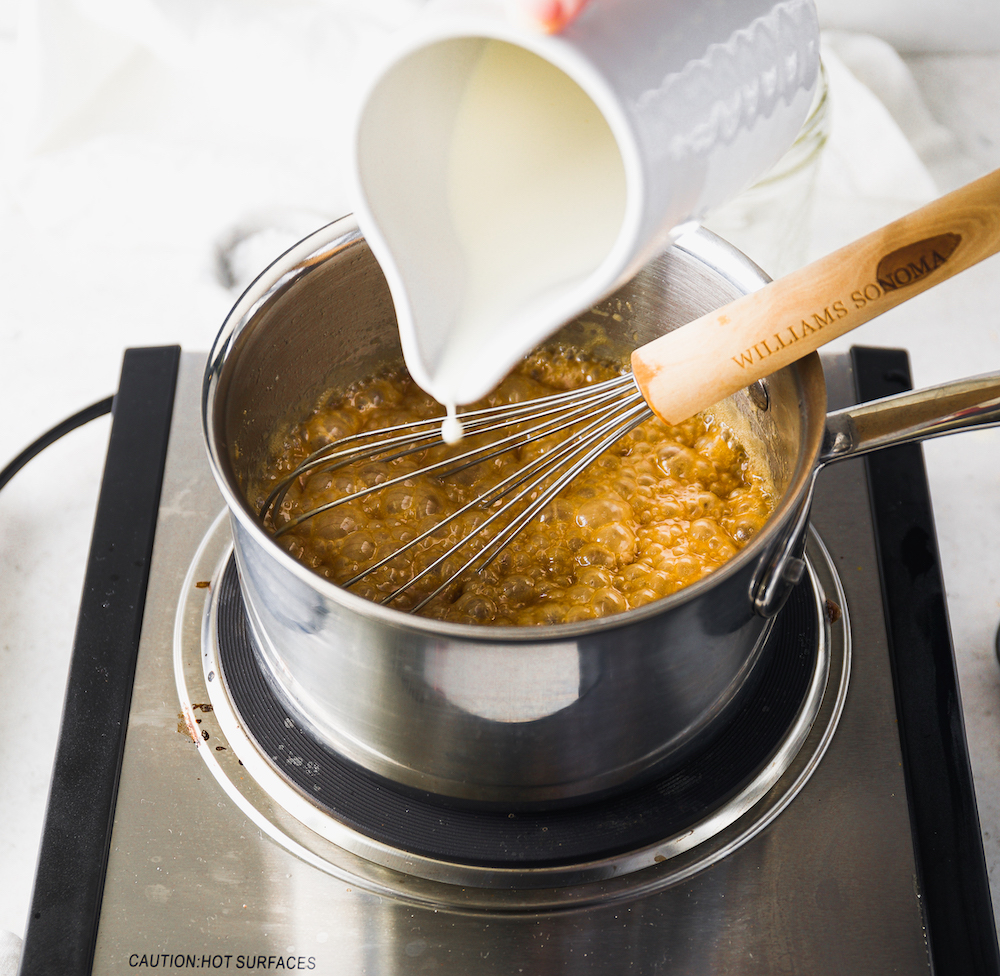 Pouring cream into a saucepan.