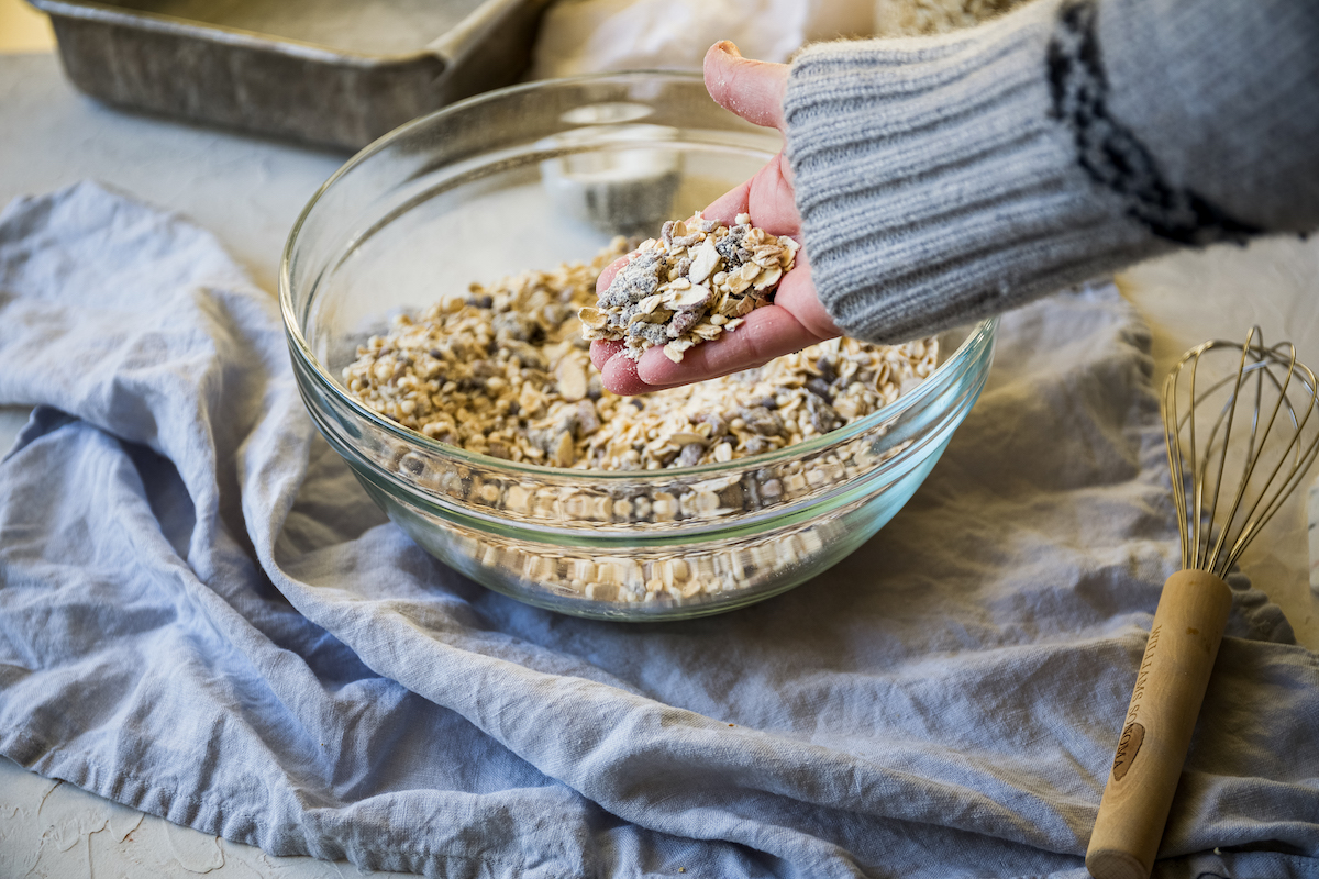 A hand holding the well-mixed granola mixture.