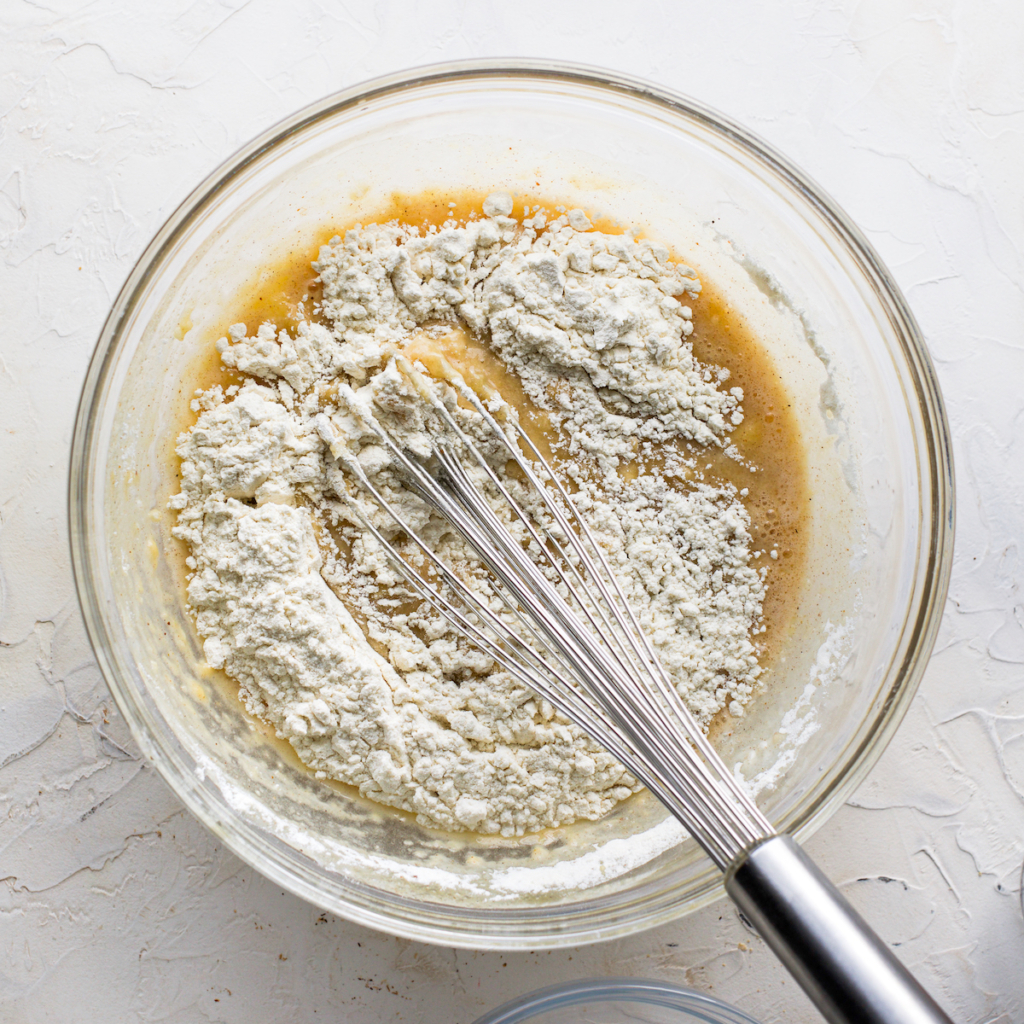Flour not mixed into muffin batter in a glass bowl.