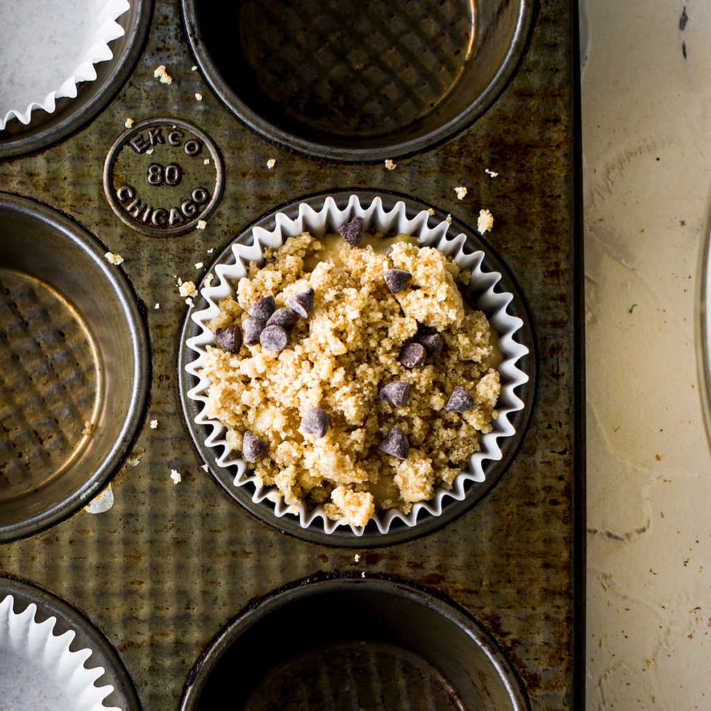 A close up of an unbaked streusel chocolate chip muffin.