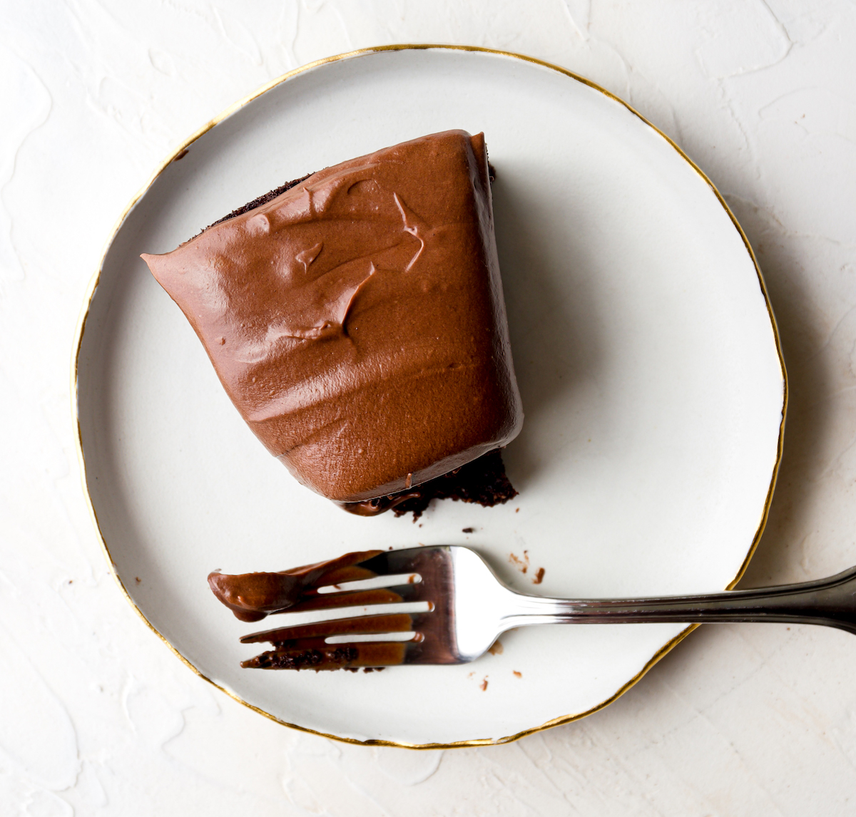 A slice of chocolate cake with a bite out of it.