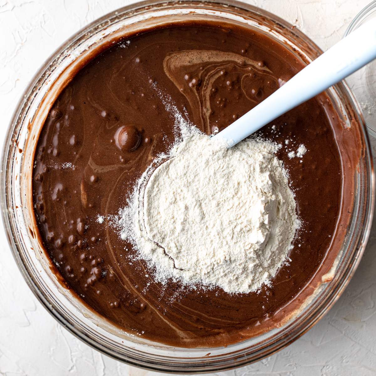 Chocolate cake batter with flour on top.