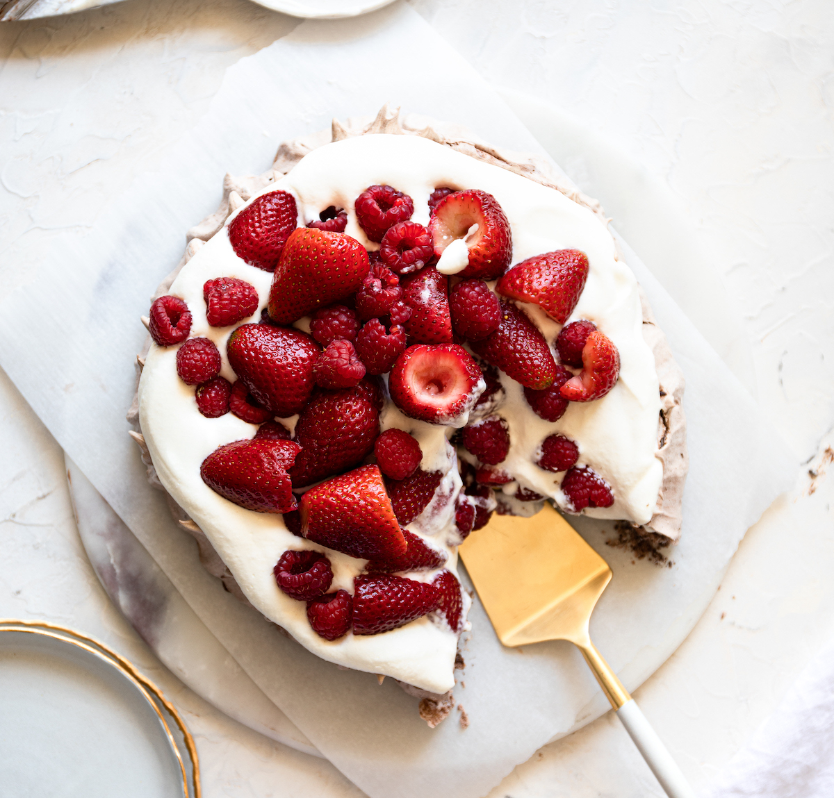 A pavlova with a  piece missing from it.