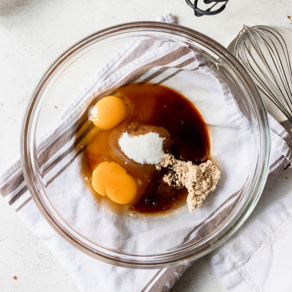 A glass bowl with eggs, sugar, vanilla and espresso.