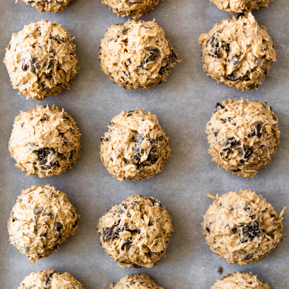 The best chewy oatmeal chocolate chip cookie dough balls on a baking sheet.