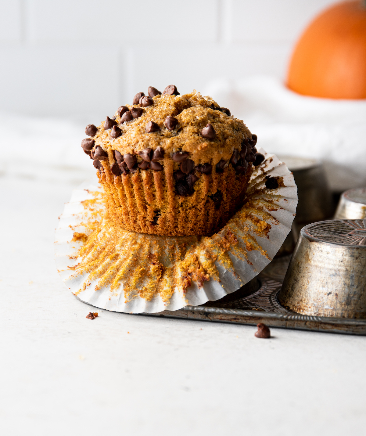 A chocolate chip pumpkin muffin with the liner pulled down.