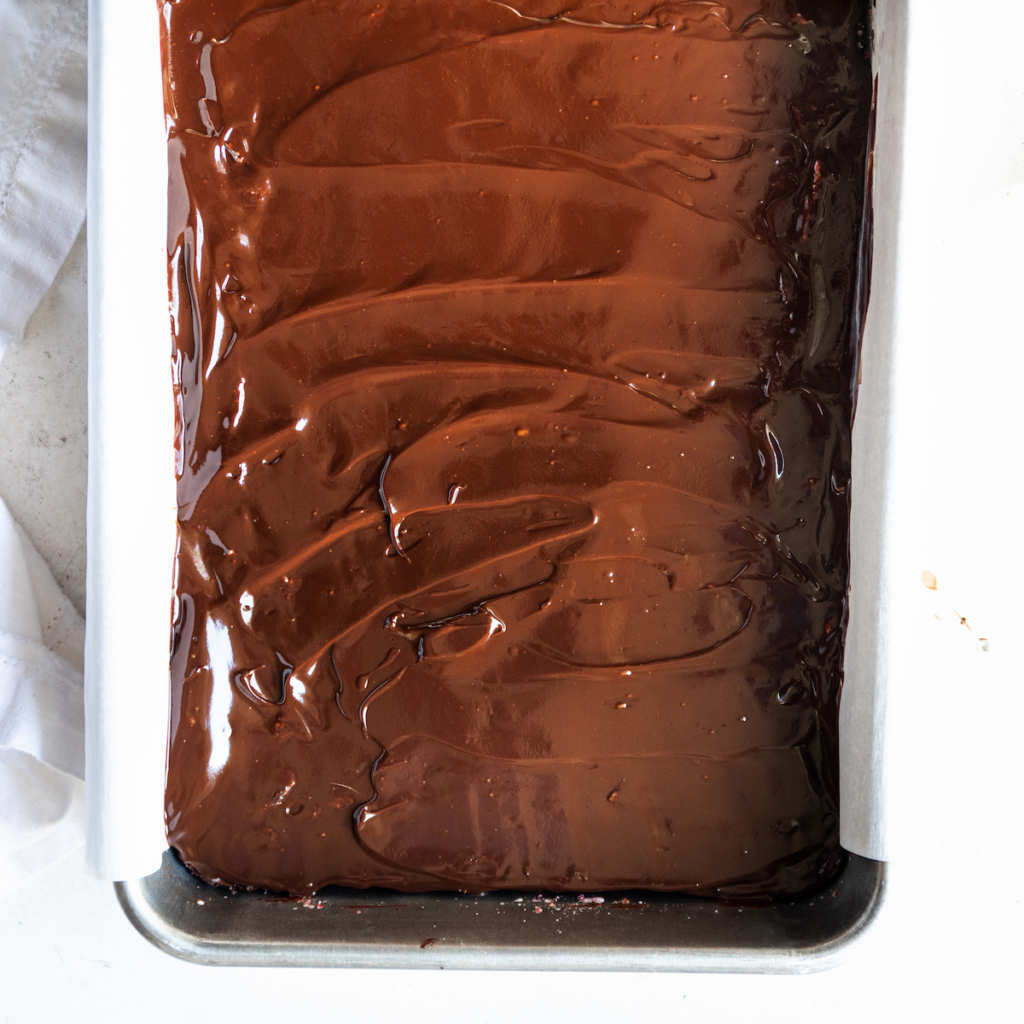 Smoothed ganache over the top of brownies.