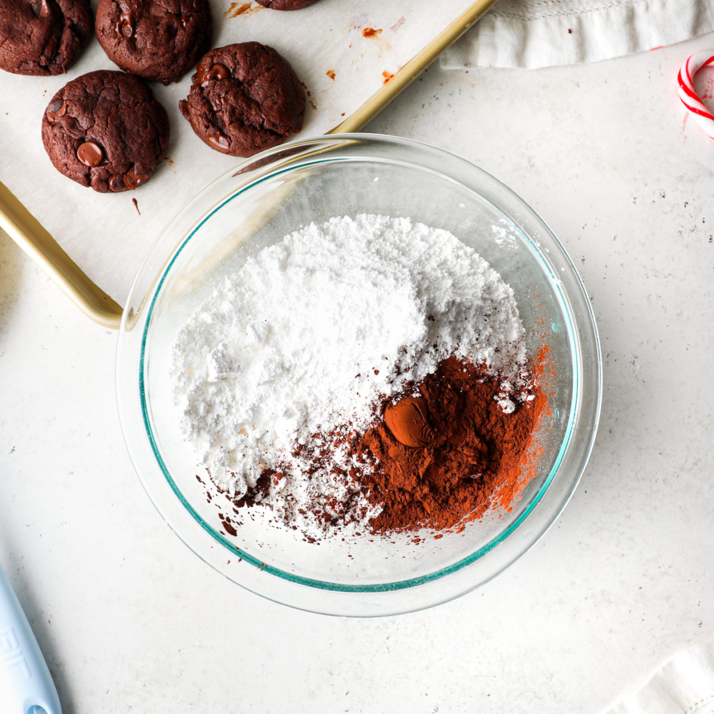 A glass bowl with confectioners sugar, cocoa powder.