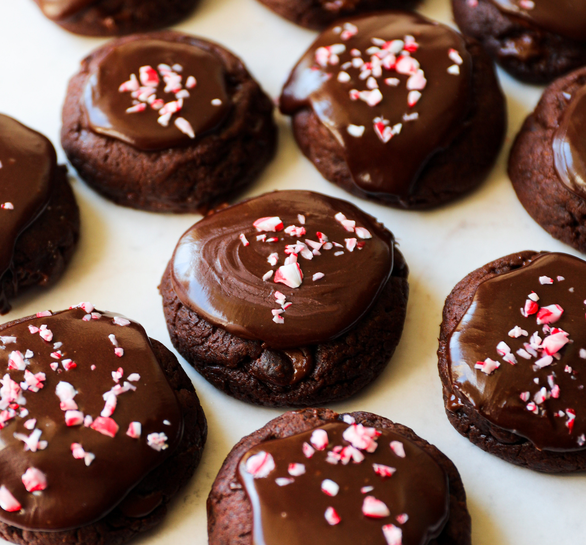 A side view of peppermint chocolate cookies that are vegan with crushed candy canes on top.