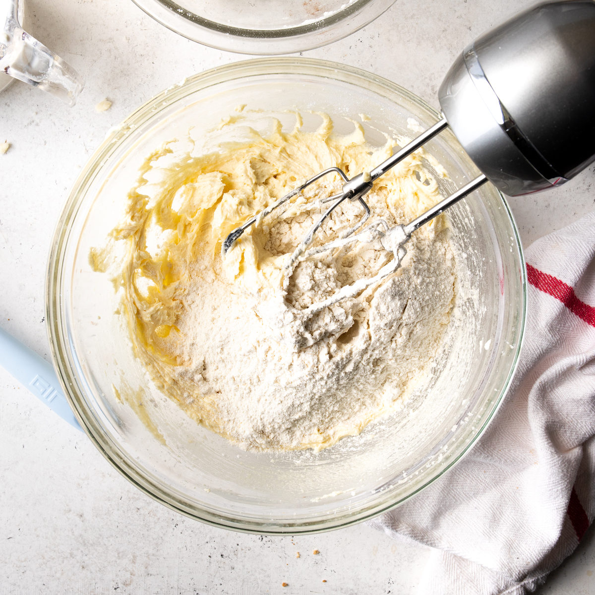 Adding half of the flour to the cake batter.