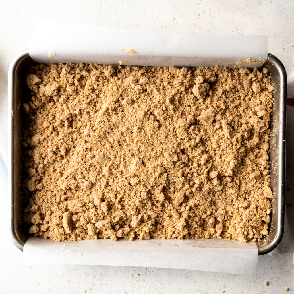 Unbaked streusel over a coffee cake.