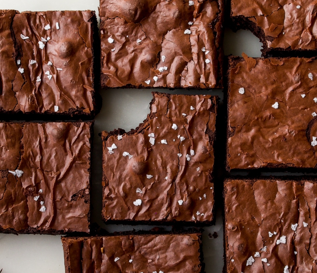 Brownie pieces fitting together like a puzzle with sea salt flakes over the tops.