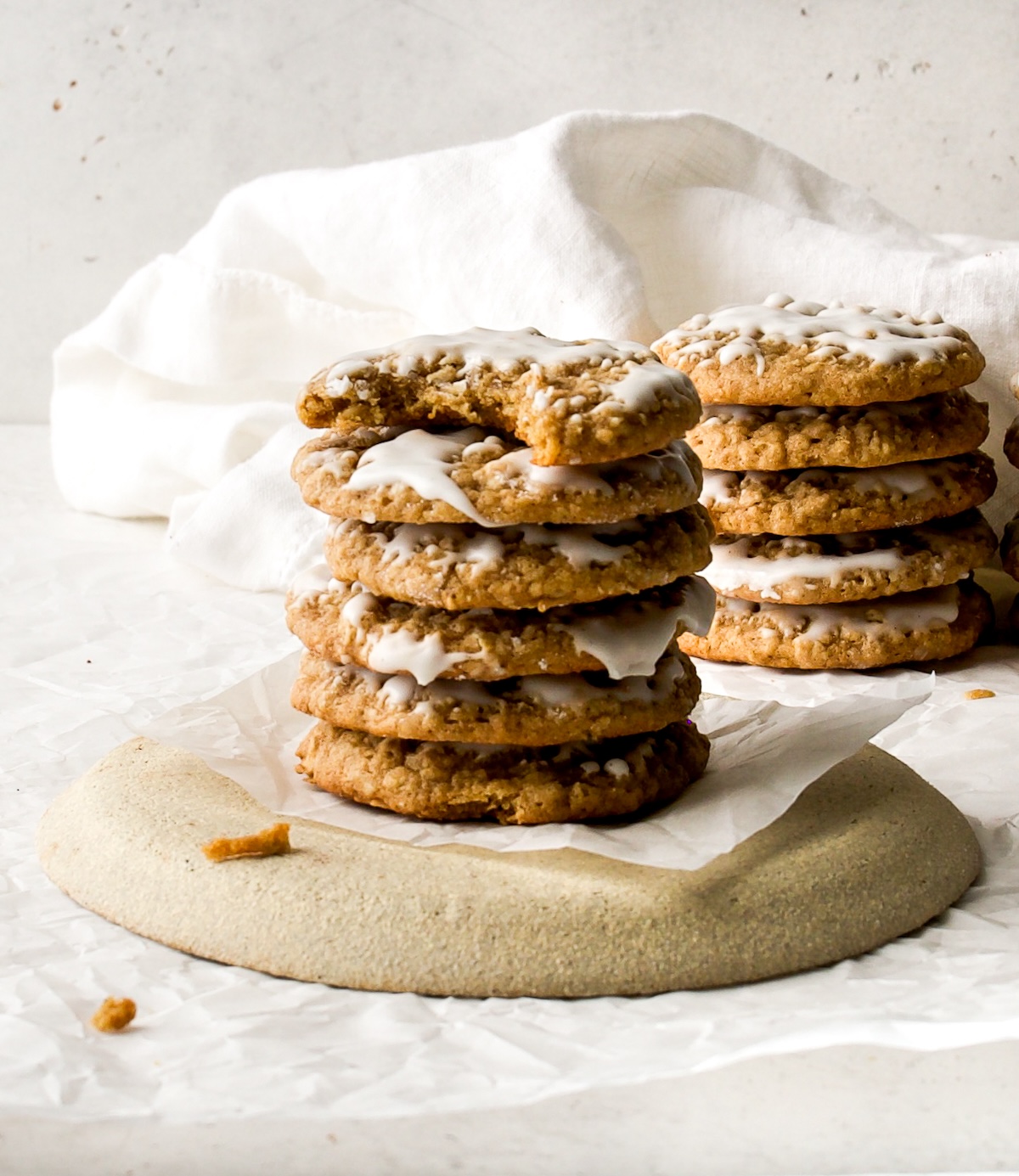 A stack of cookies on a piece of parchment with a white background.