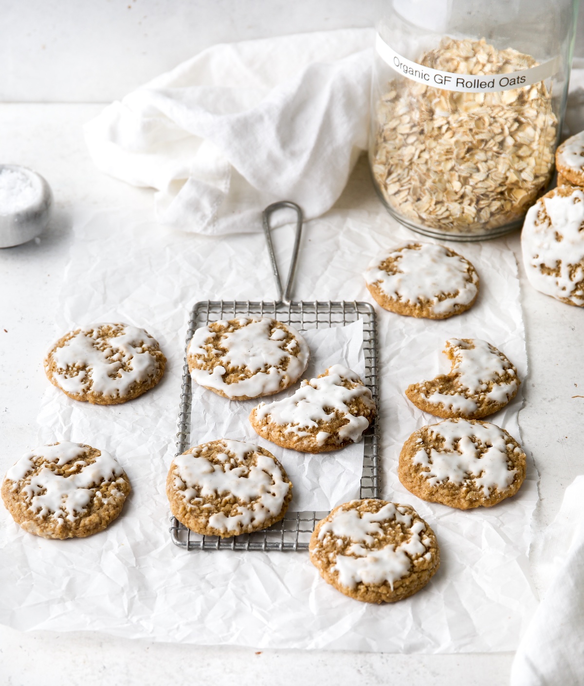 Iced oatmeal cookies on a white surface.