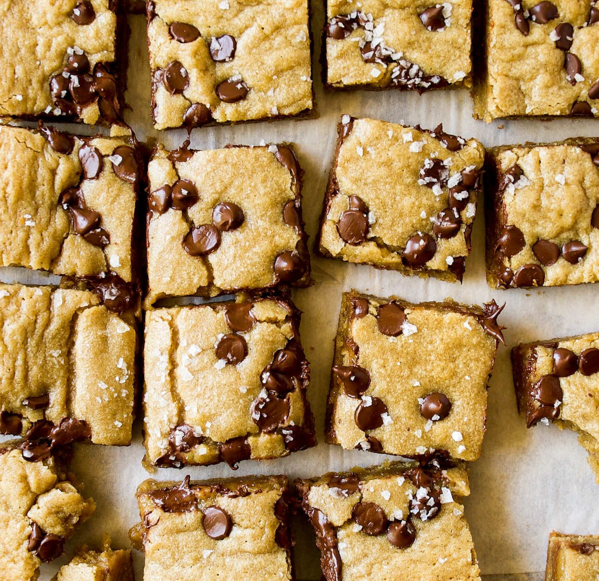 A bunch of pieces of brown butter blondie with chocolate chips and sea salt flakes.