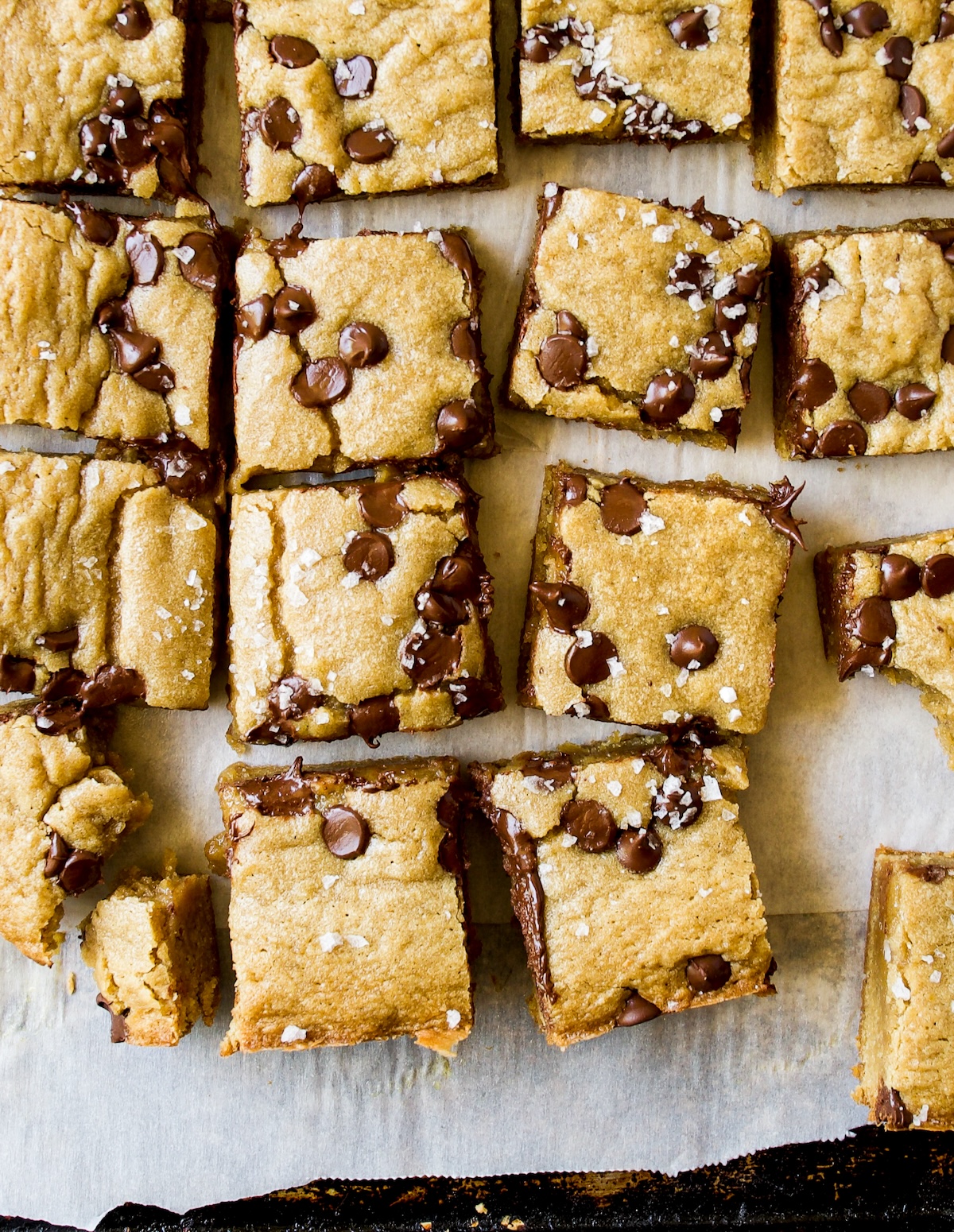 A bunch of little pieces of blondies on a white surface.