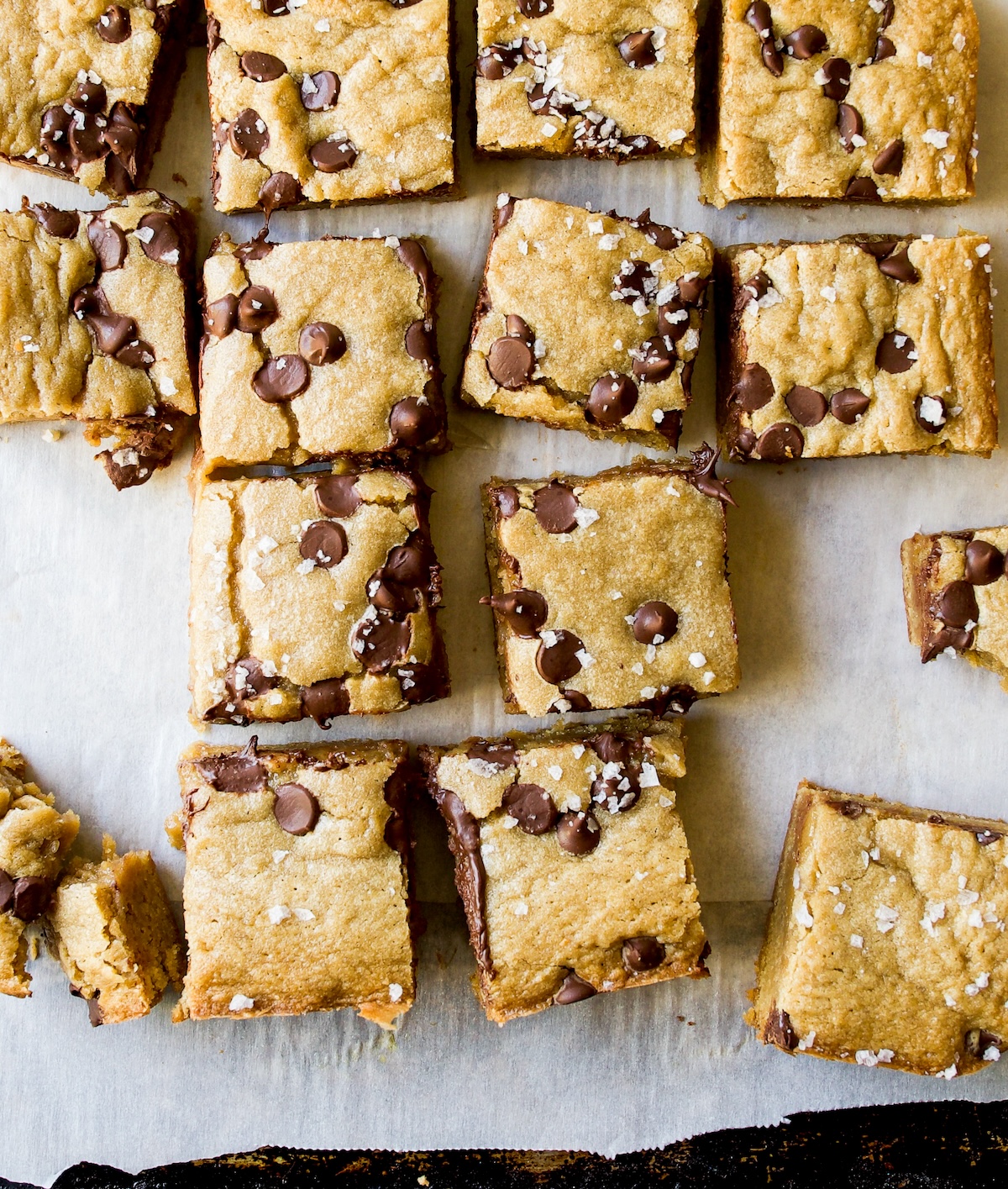 A bunch of really cute blondie cookies with chocolate chips.