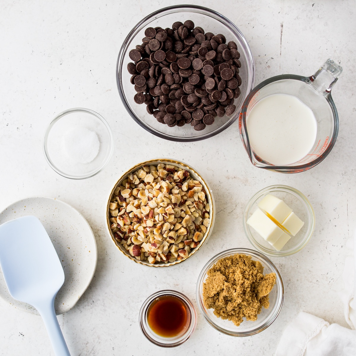 All of the ingredients needs to make homemade nutella on a white surface.