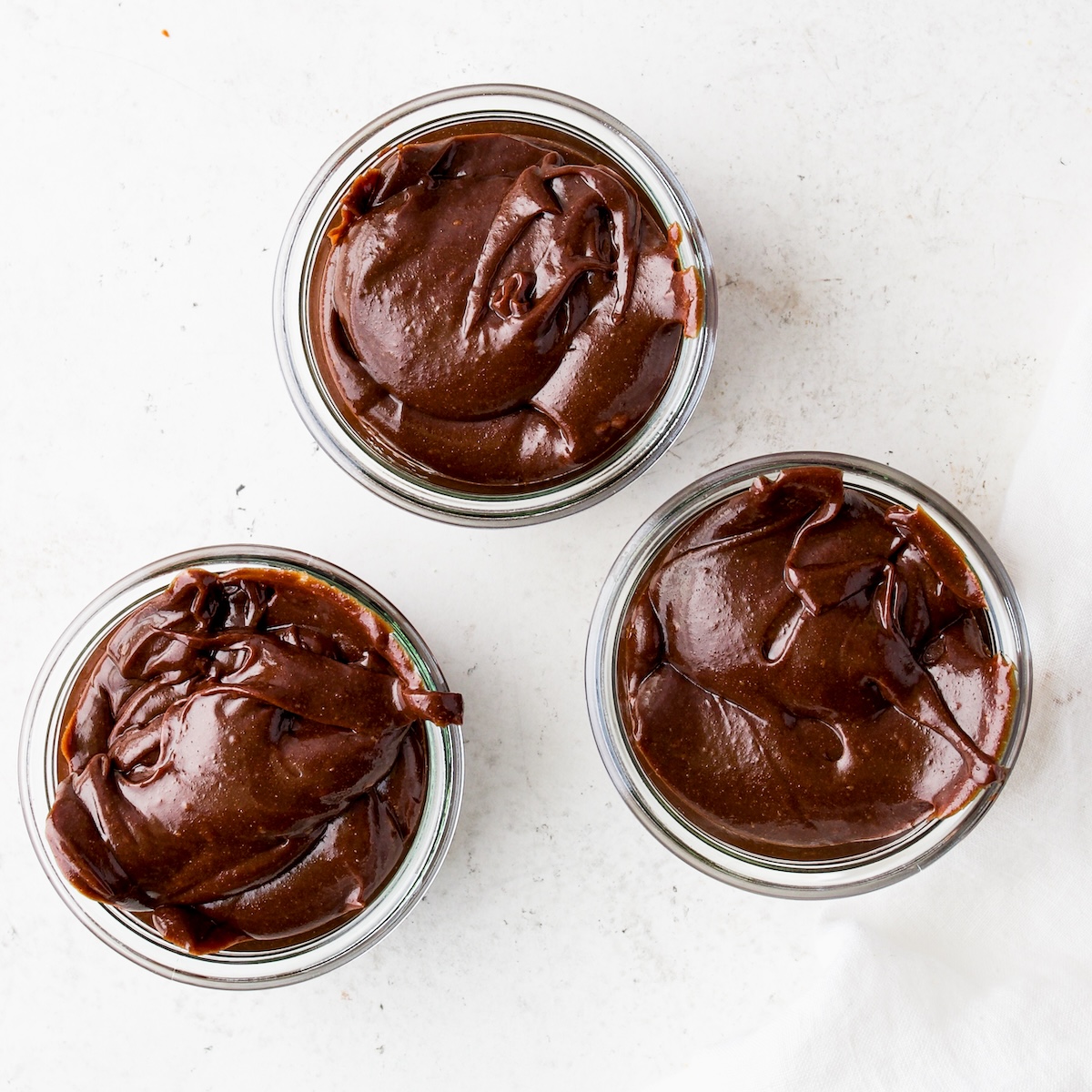 Three glass jars with homemade nutella spread.